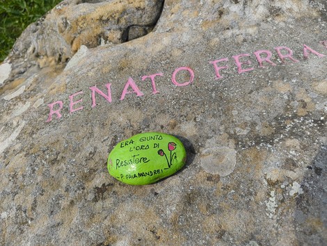 Monumento ai partigiani caduti a Monte Sabbiuno, con un messaggio di resistenza sulla pietra.