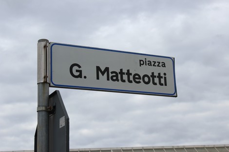 Targa stradale che indica piazza G. Matteotti con sfondo nuvoloso.