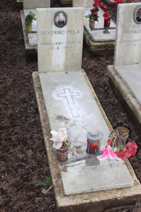 Tombe perpetue dei caduti per la Libertà, decorate con fiori e candele in un cimitero.