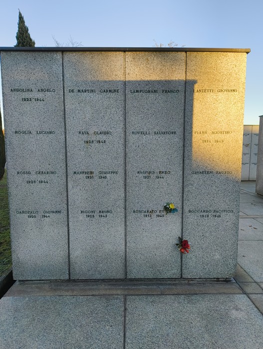 Il Campo della Gloria con una parete commemorativa di granito e fiori posati in ricordo dei defunti.