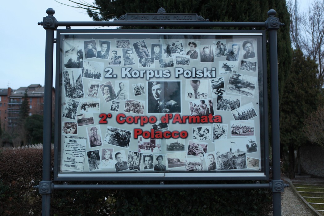 Immagine del Cimitero di guerra polacco con pannelli commemorativi e fotografie storiche dei soldati.