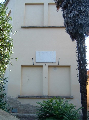 Lapide commemorativa ai caduti del quartiere 7, visibile su una parete esterna, circondata da vegetazione.