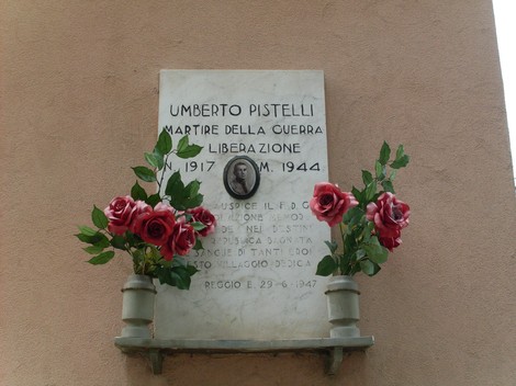 Lapide commemorativa di Umberto Pistelli, martire della guerra di liberazione, decorata con rose.
