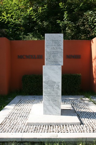 Monumento a Montolli, commemorazione di eventi storici con stele centrale e decorazioni floreali.