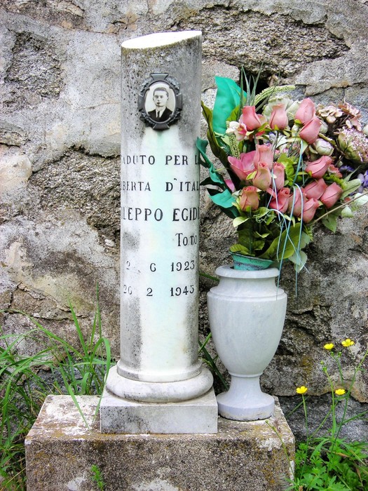 Cippi commemorativi di Berbotto e Fileppo, con fiori e decorazioni, in un contesto naturale suggestivo.