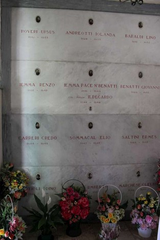 Sacrario dei caduti per la libertà di Cavezzo, con lapidi commemorative e fiori in omaggio.