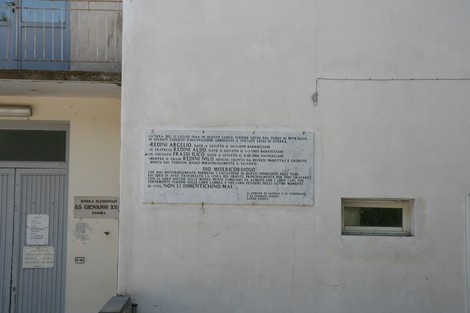Lapide commemorativa della scuola di Zambra, dedicata alla memoria di significativi eventi storici.