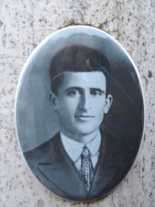 Ritratto in bianco e nero su cippo commemorativo di un individuo del passato.