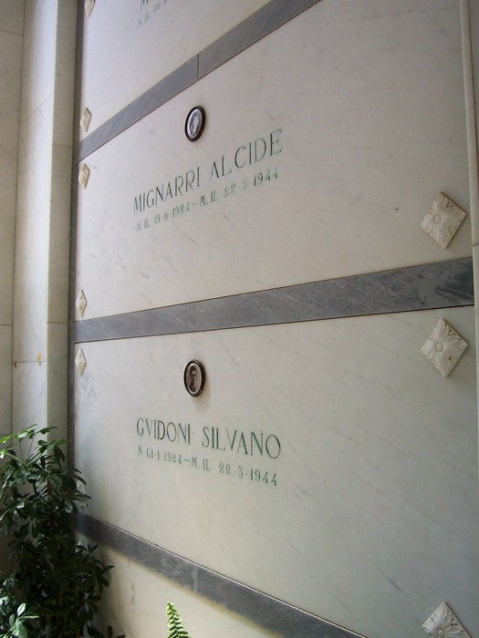 Interno della Cappella dei Caduti di Istia d'Ombrone, mostrando loculi marmorei in un'atmosfera di commemorazione.