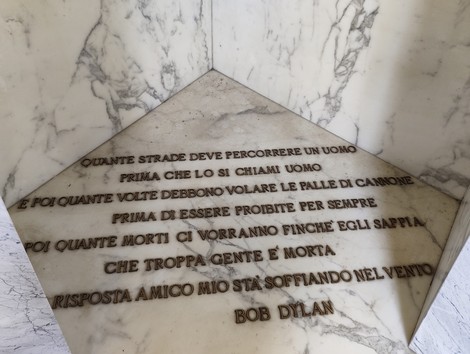 Sacrario dei caduti con iscrizioni commemorative su lastre di marmo, simbolo di memoria e riflessione.