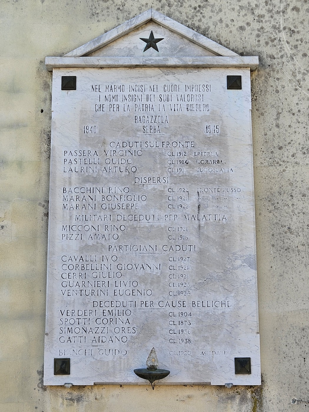 Lapide commemorativa dedicata ai caduti della guerra 1940-1945, con iscrizioni di nomi e onori.
