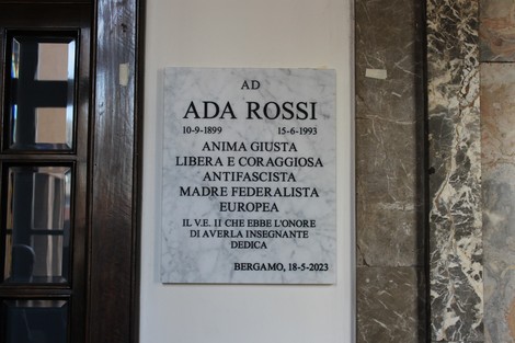 Lapide commemorativa in marmo dedicata a Ada Rossi, con iscrizioni sul suo impegno e valore.