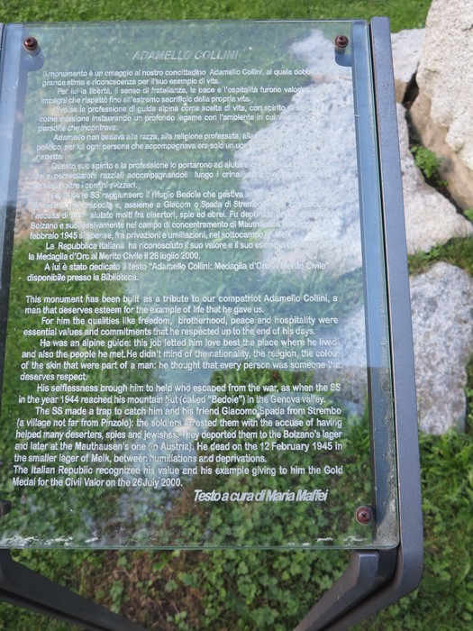 Monumento a Collini, dedicato al commediografo, circondato da un verde paesaggio e sculture in pietra.