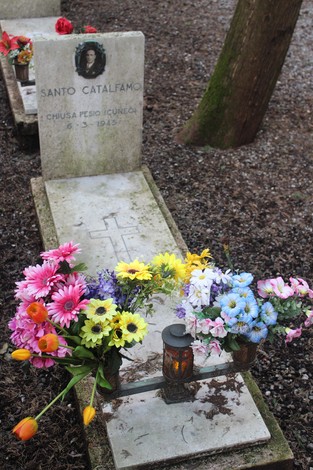 Tombe decorate con fiori colorati in un cimitero, dedicate ai caduti per la libertà.
