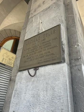 Targa commemorativa dedicata a Luciano Bolis, situata in un edificio storico.