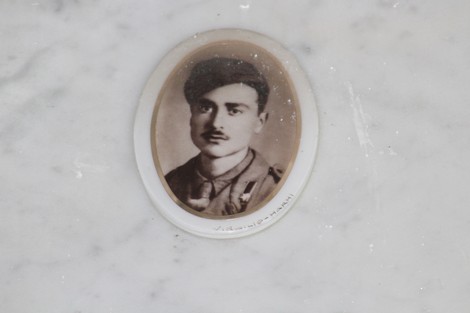 Immagine di un ritratto in bianco e nero di un soldato, incastonato in una cornice ovale su fondo marmoreo.