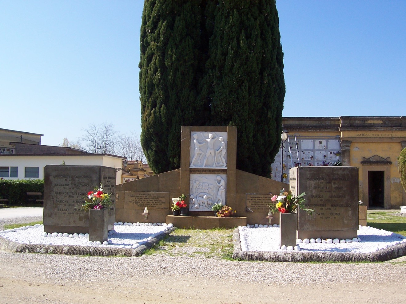 Monumento commemorativo dedicato ai bambini del collegino di Colonnata, con fiori e decorazioni.