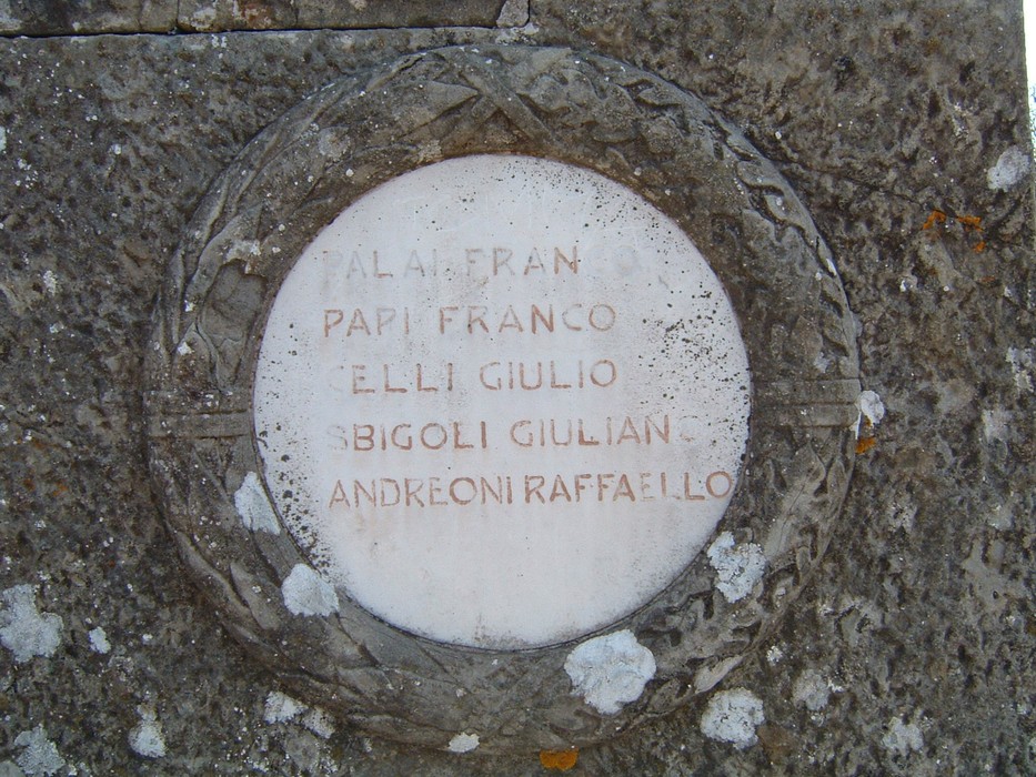 Monumento in Secchieta, un tributo storico inciso su marmo, immerso nella natura.