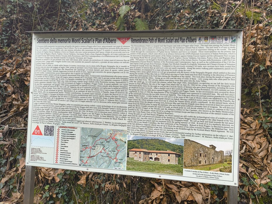 Insegna informativa sul Sentiero della Memoria di Monti Scalari e Pian d'Albero, circondata da vegetazione.