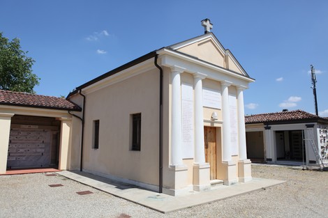 Il Sacrario dei Caduti per la Liberazione, con facciata semplice e colonne bianche, si trova in un ambiente sereno.