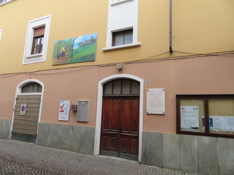 Lapide commemorativa della battaglia di Balmafol su una parete di un edificio storico in un contesto urbano.