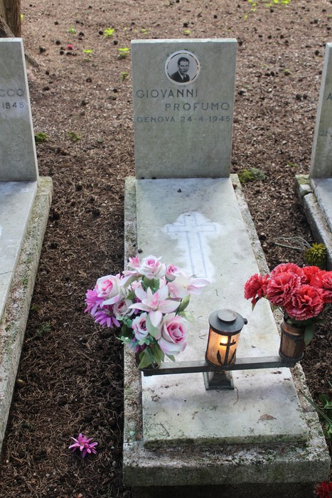 Tombe dei caduti per la Libertà, decorate con fiori e lumini, evocano un'atmosfera di rispetto e memoria.