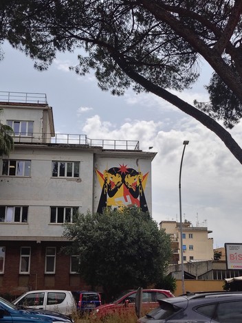 Murale ai caduti per la difesa di Roma, affrescato su un edificio in un contesto urbano.