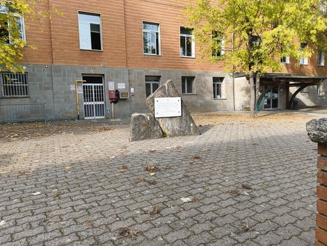 Monumento ai combattenti per la Libertà, situato in un'area urbana, circondato da edifici e vegetazione.