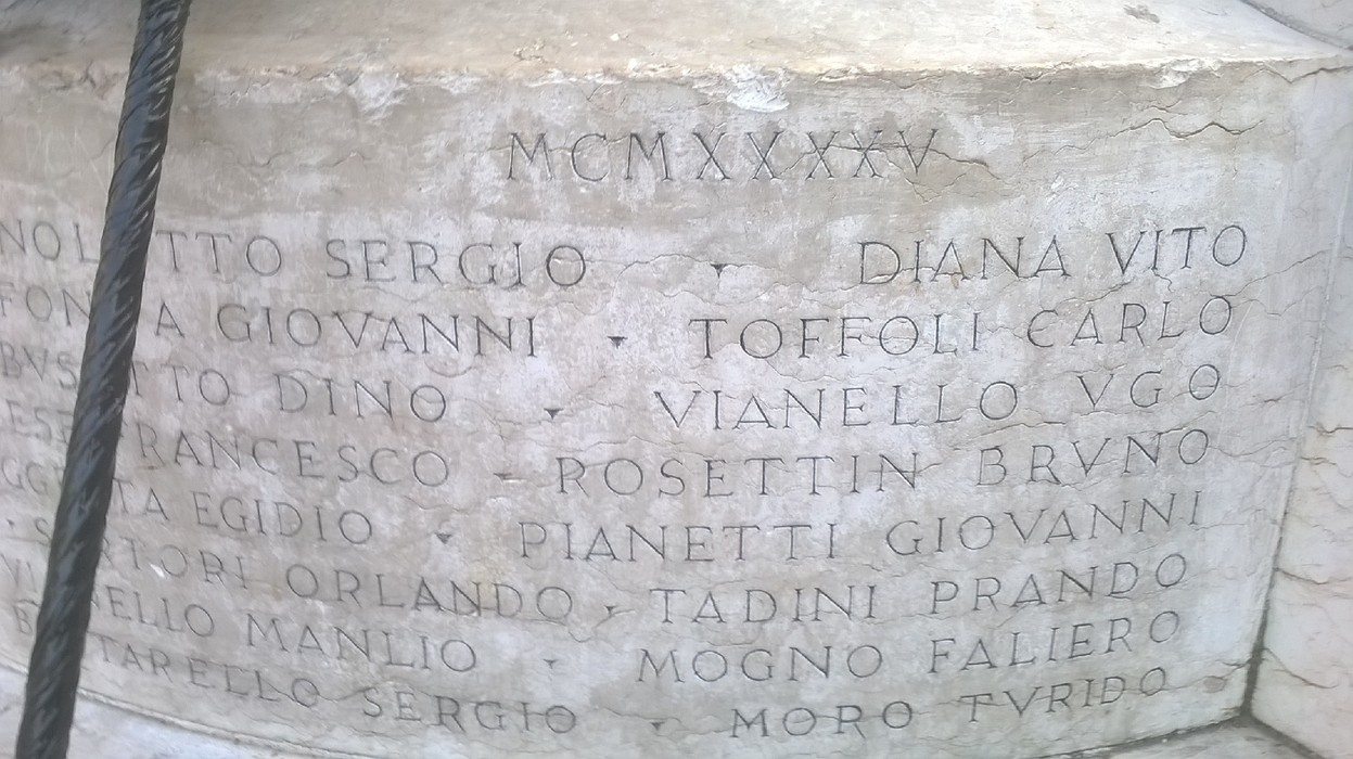 Monumento ai caduti dei Carmini con nomi incisi su lastre di pietra. Atmosfera solenne e commemorativa.