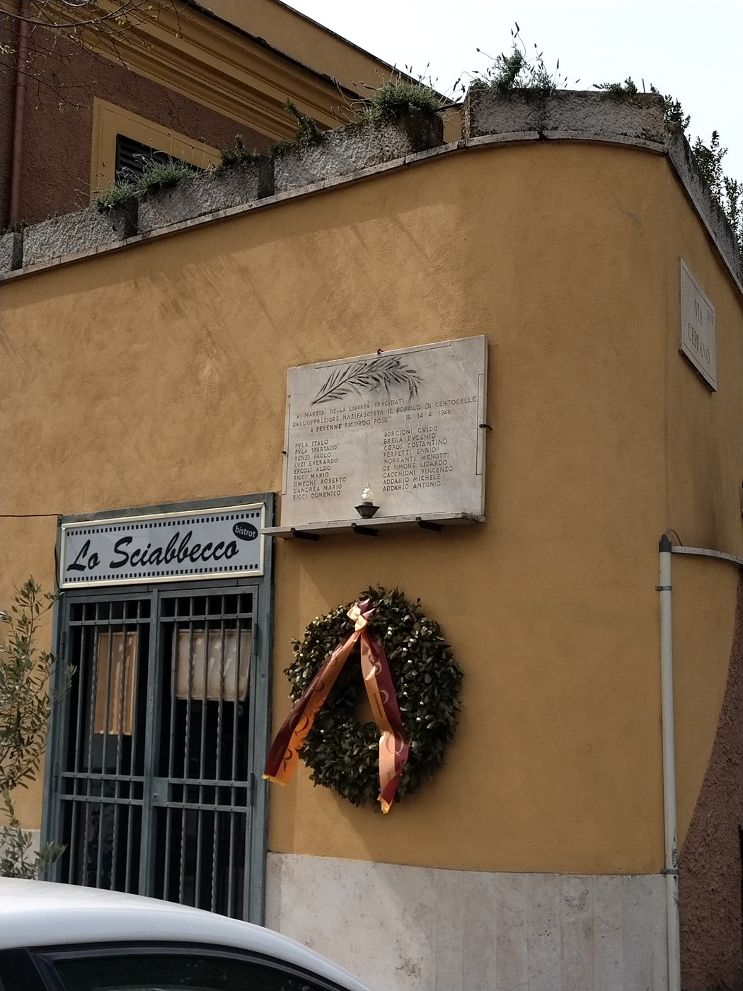 Lapide commemorativa in muratura con corona di alloro, dedicata ai caduti per la libertà di Centocelle.