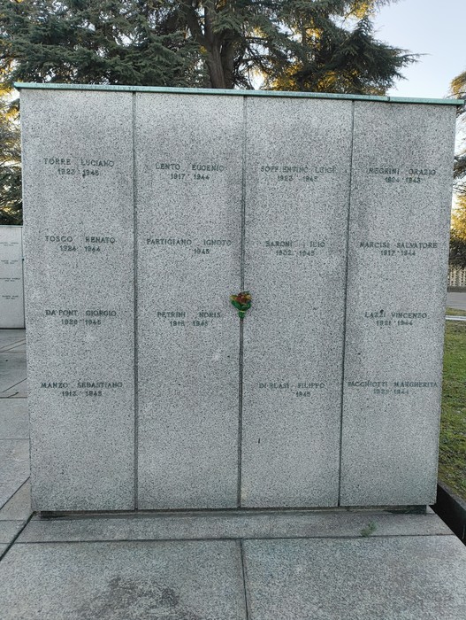 Monumenti commemorativi nel Campo della Gloria, con iscrizioni e omaggi floreali.
