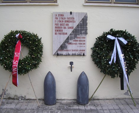 Lapide commemorativa all'ingresso della Caserma Lamarmora, con corone di fiori a memoria dei partigiani.