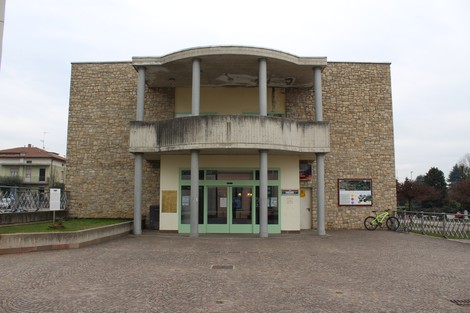 Edificio con facciata in pietra, dotato di colonne e ampie vetrate, situato in un'area pubblica.