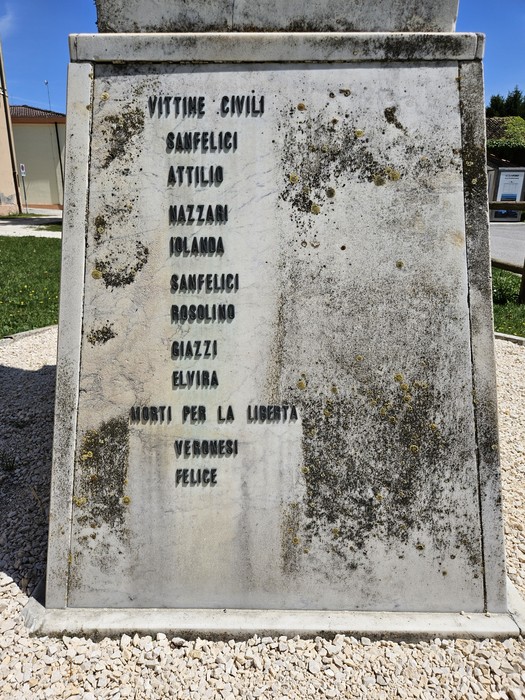 Monumento ai Caduti con nomi di vittime civili inciso su pietra, in un contesto sereno e rispettoso.