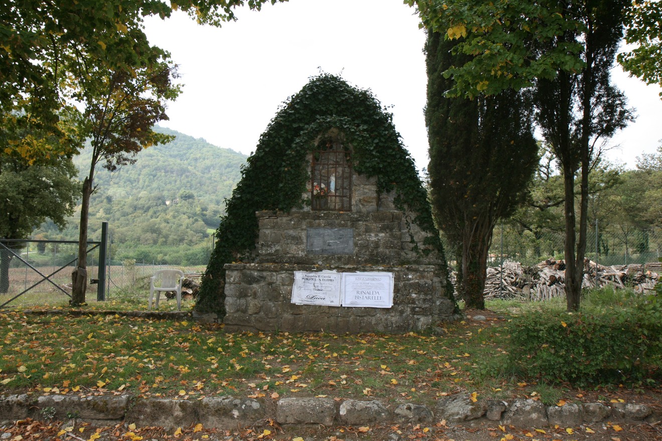 Tabernacolo di Falzano, piccolo edificio religioso incastonato nella vegetazione, immerso nel paesaggio naturale.