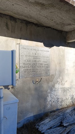 Lapide commemorativa di Carlo Huafa, Francesco Enri e Carlo Trattenero, affissa su un muro.