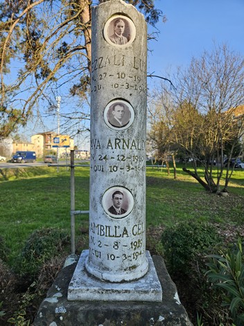 Cippo commemorativo con ritratti di Fava, Brambilla e Pezzali, situato in un'area verde.