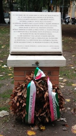 Monumento commemorativo della battaglia della Bolognina, con dedica e decorazione floreale.