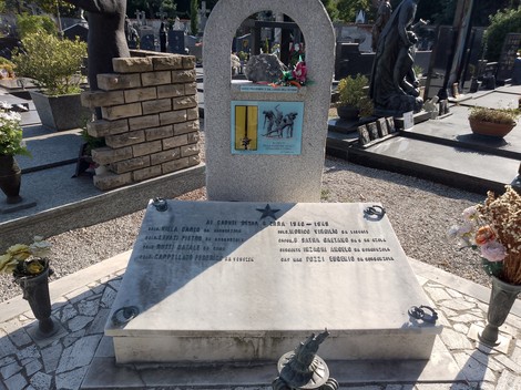 Monumento ai caduti della Divisione Acqui, commemorazione con lapidi e fiori in un cimitero.