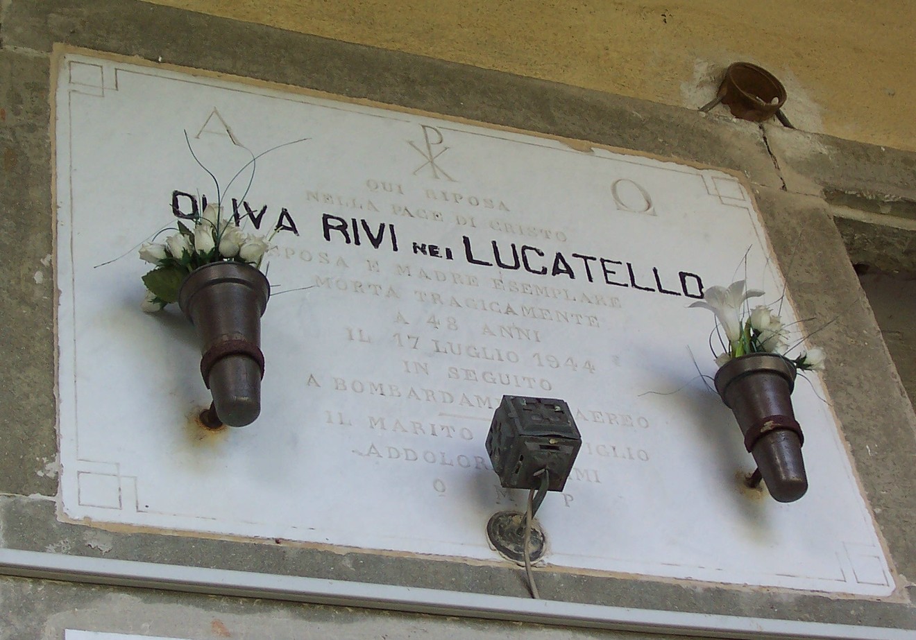 Sepolcro di Oliva Rivi, omaggio a un martire della Seconda Guerra Mondiale, decorato con fiori.
