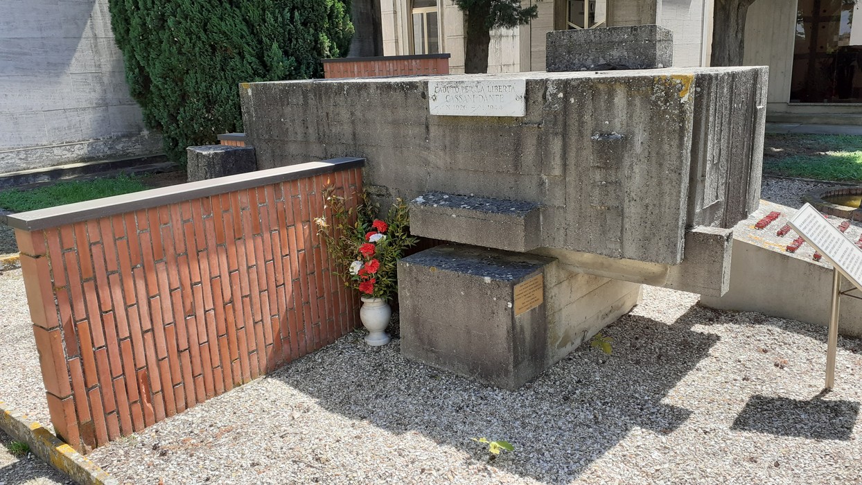 Sepocro di Cassani, monumento commemorativo con elementi in cemento e decorazioni floreali.
