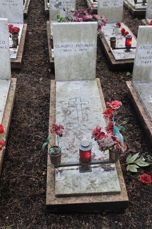 Tombe perpetue decorate con fiori e candele, commemorano i caduti per la libertà. Atmosfera di rispetto e memoria.