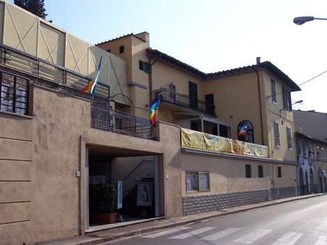 Lapide del Circolo "L'Unione", edificio storico con bandiere e affissi decorativi.