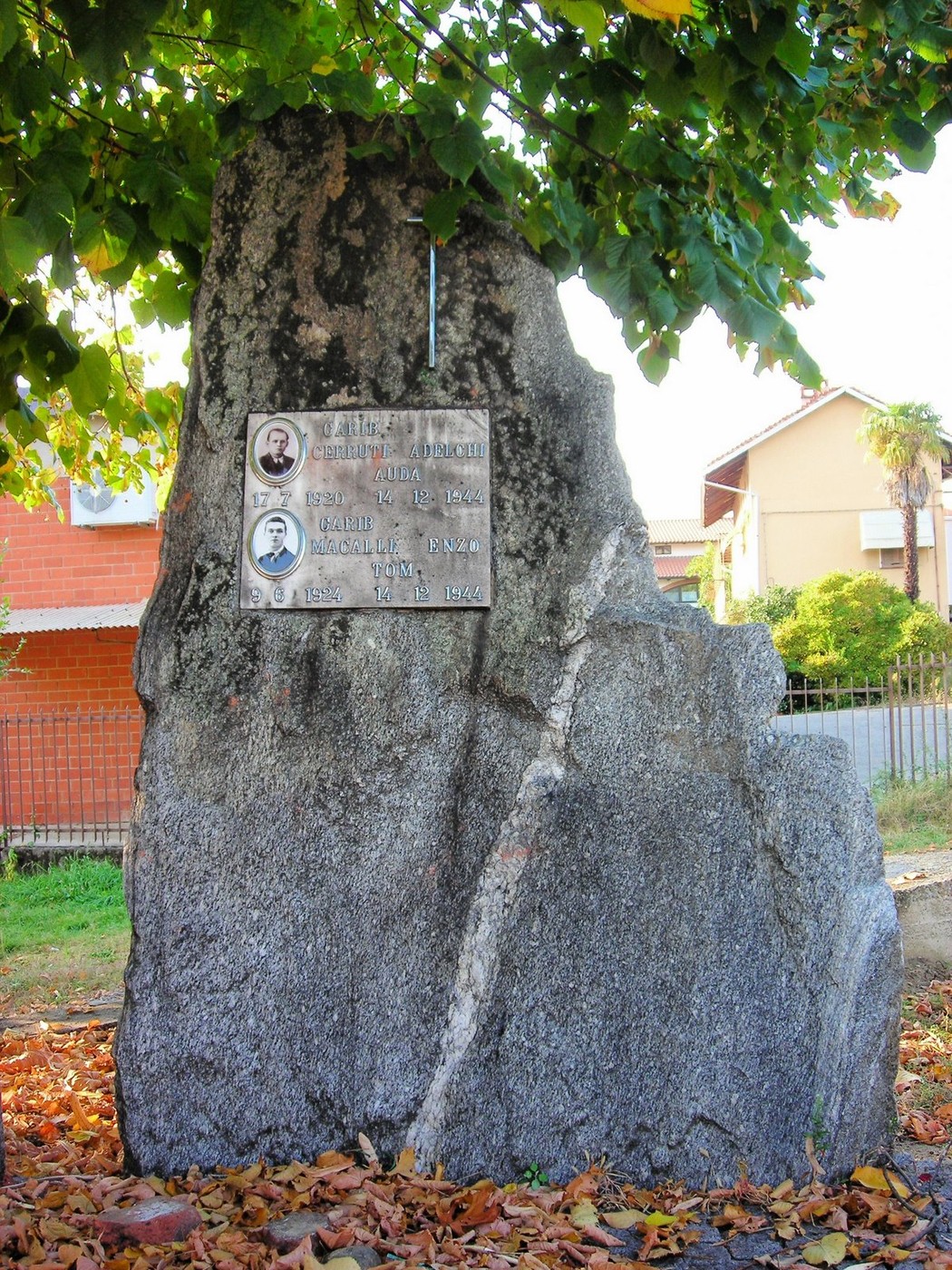 Monumento in pietra dedicato a Cerruti e Macalli, circondato da alberi e foglie autunnali.