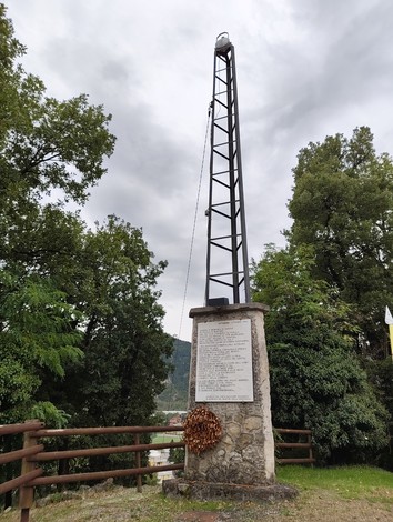 Il Faro è un monumento caratterizzato da una struttura slanciata, circondato da alberi e con un cielo nuvoloso.