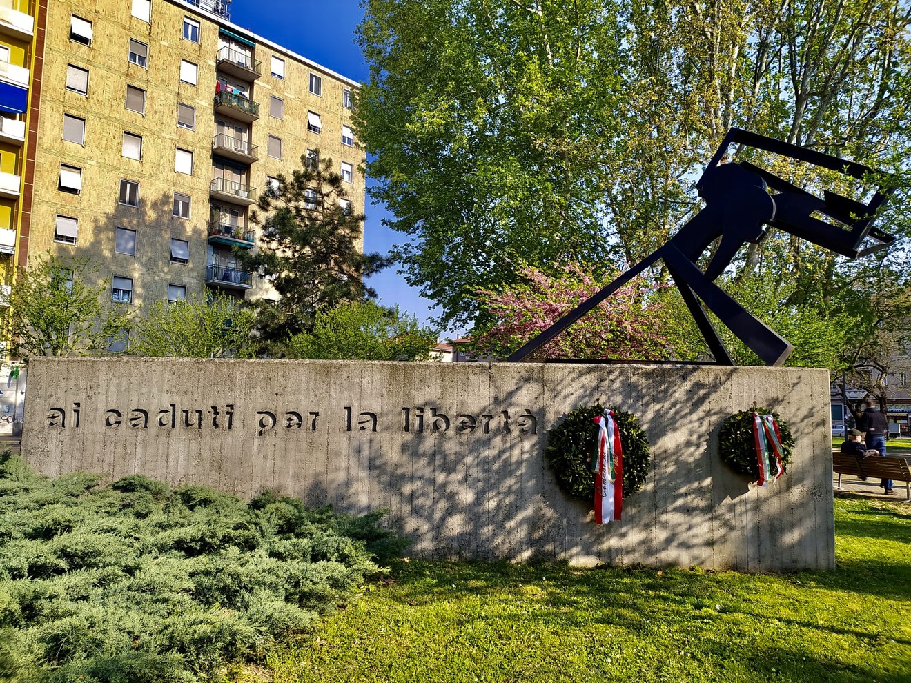 Monumento ai partigiani della Barona, con scritte commemorative e decorazioni floreali in memoria dei caduti.