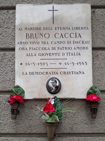 Lapide commemorativa dedicata a Bruno Caccia, martire della libertà, con fiori decorativi.