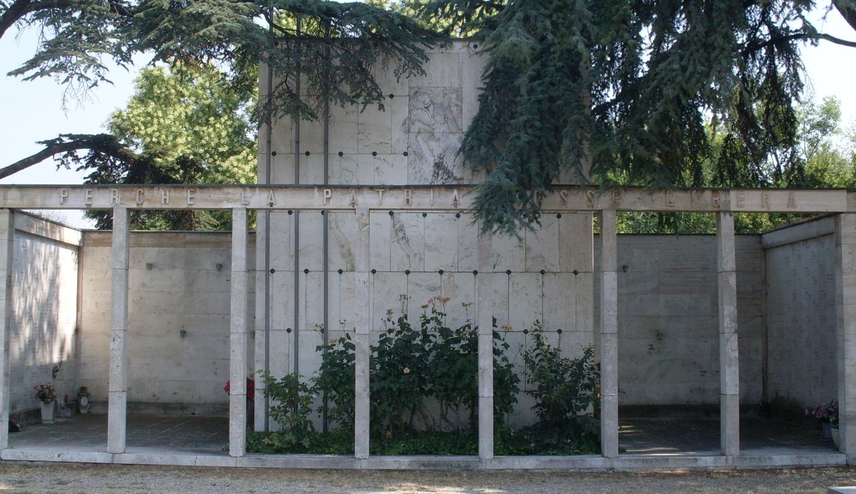 Monumento ai Caduti Partigiani, struttura in cemento con vegetazione e un design sobrio e commemorativo.