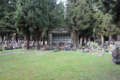 Sacrario dei caduti per la Liberazione, con cimitero e monumento circondati da alberi. Atmosfera di rispetto e commemorazione.
