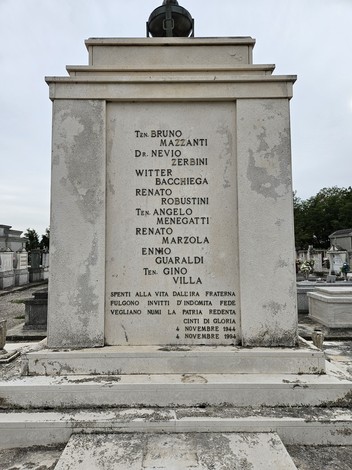 Monumento ai Caduti della Resistenza, con iscrizioni commemorative su una stele in un cimitero.